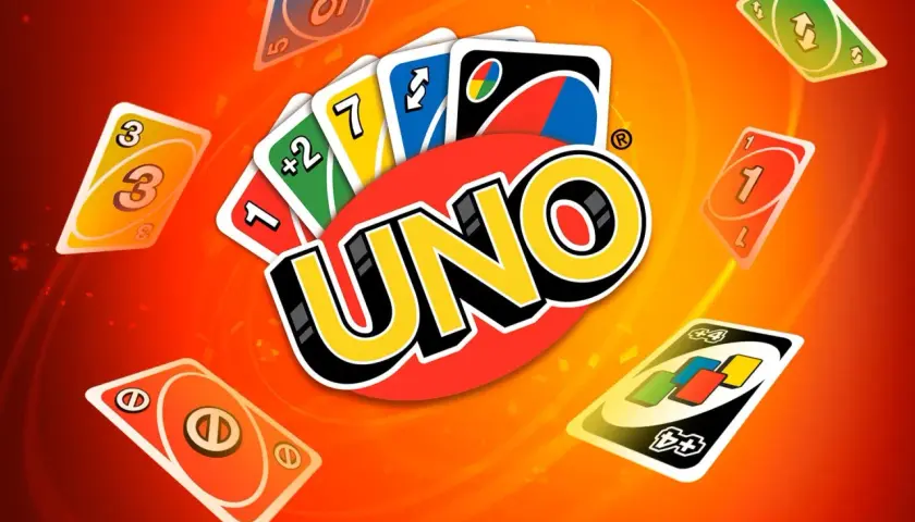 Karty UNO, w tym karta "zmiana kolejki", unoszą się na pomarańczowym tle.