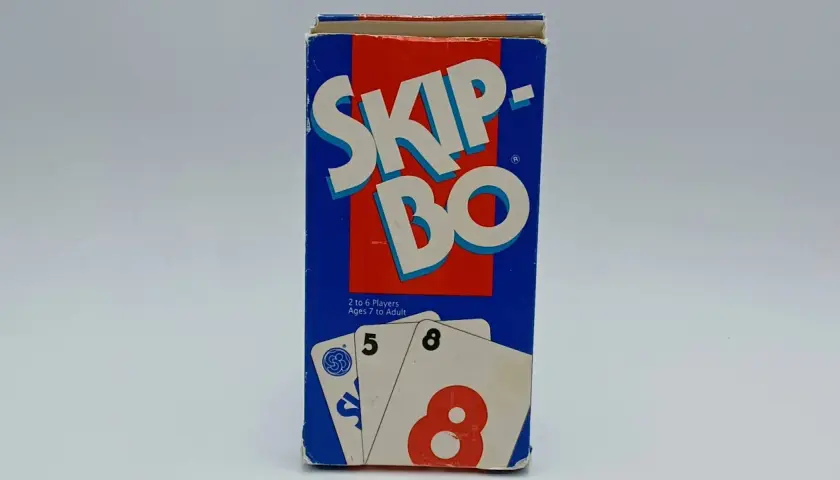 Pudełko gry karcianej Skip-Bo, z widocznymi kartami 5 i 8. Idealne do nauki zasad gry.