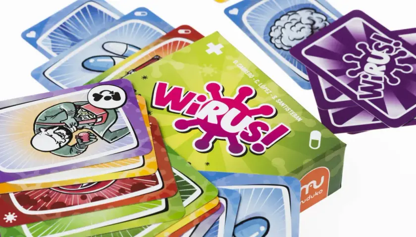 Kolorowe karty do gry "Wirus!" przedstawiają elementy medyczne i wirusy. Na jednej z kart widać postać wstrzykującą sobie coś z strzykawki.