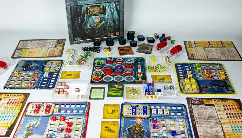 Rozłożone planszówki RPG: kostki, żetony i plansze do gry "Gloomhaven: Szczęki Lwa".