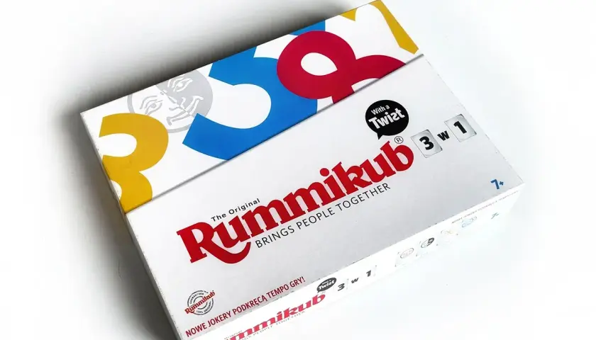 Pudełko gry Rummikub z hasłem "BRINGS PEOPLE TOGETHER". Poznaj zasady Rummikub i ciesz się grą!