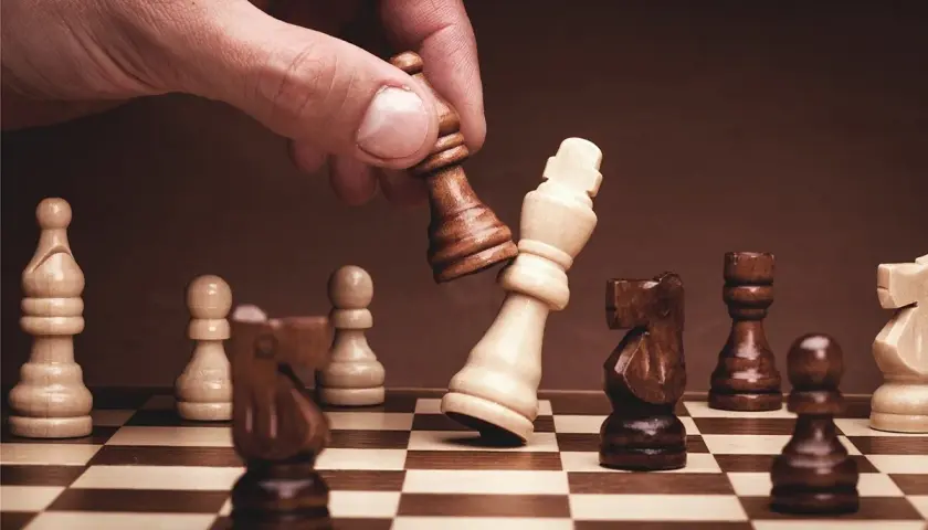 Dłoń gracza zbija króla przeciwnika. Poznaj szachy zasady i strategię gry.